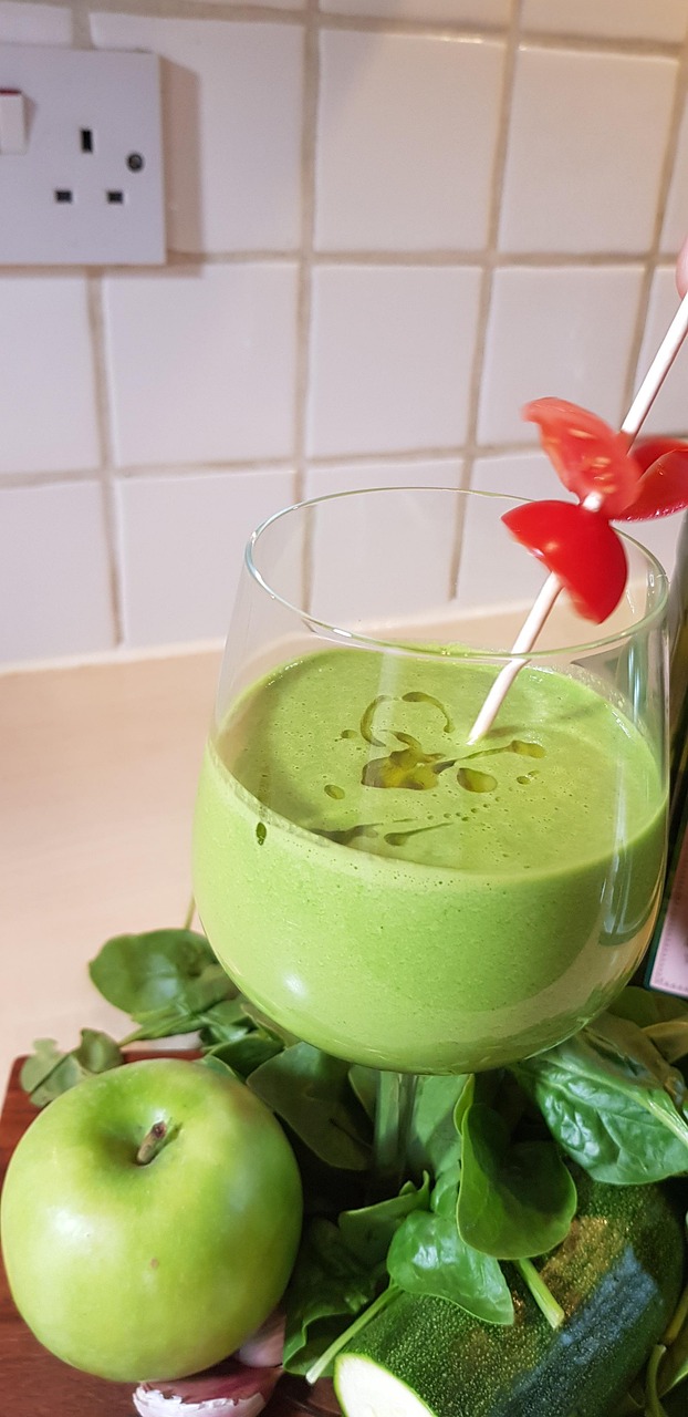 Frappè verde detox con spinaci e banana, servito in un bicchiere con decorazioni fresche.