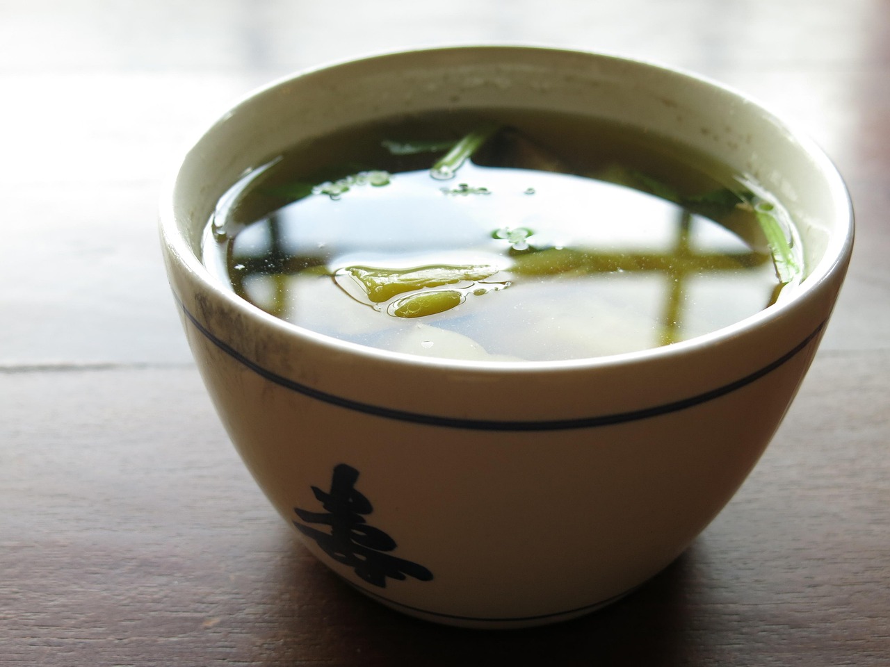 Zuppa di miso giapponese servita in una ciotola con verdure fresche e colorate.