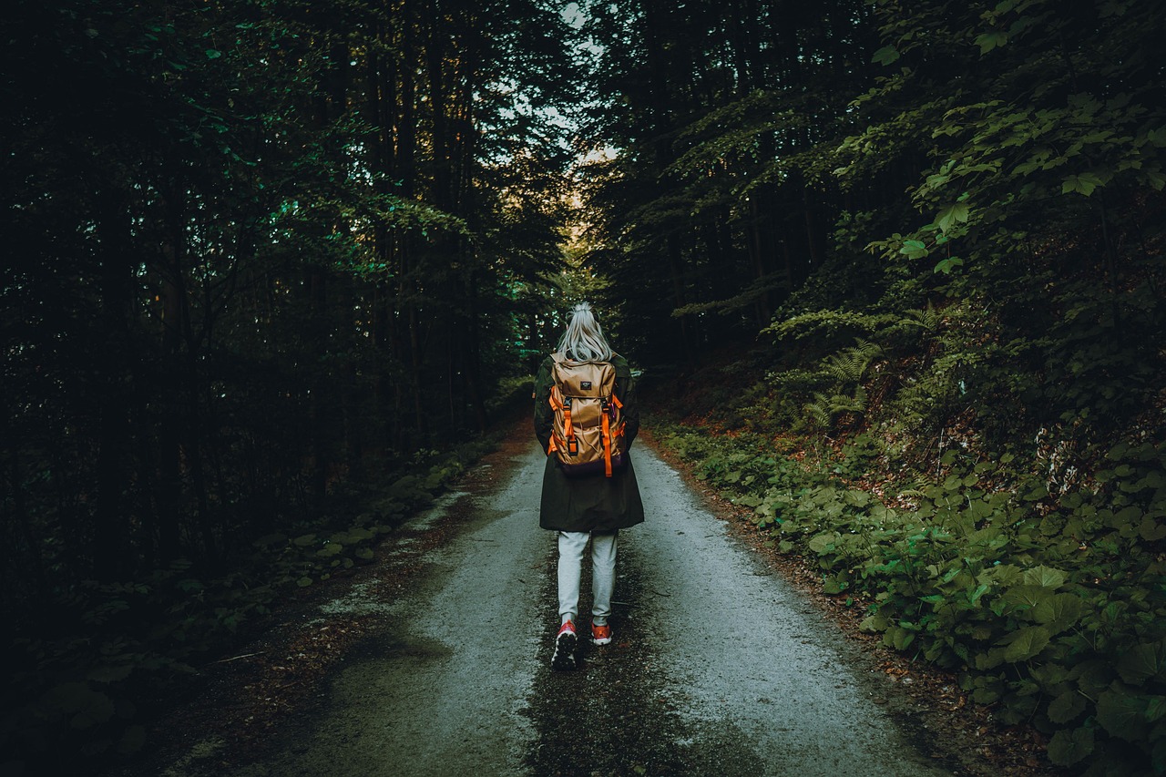 Due persone che camminano in un bosco, circondate dalla natura, sorridendo e rilassandosi.