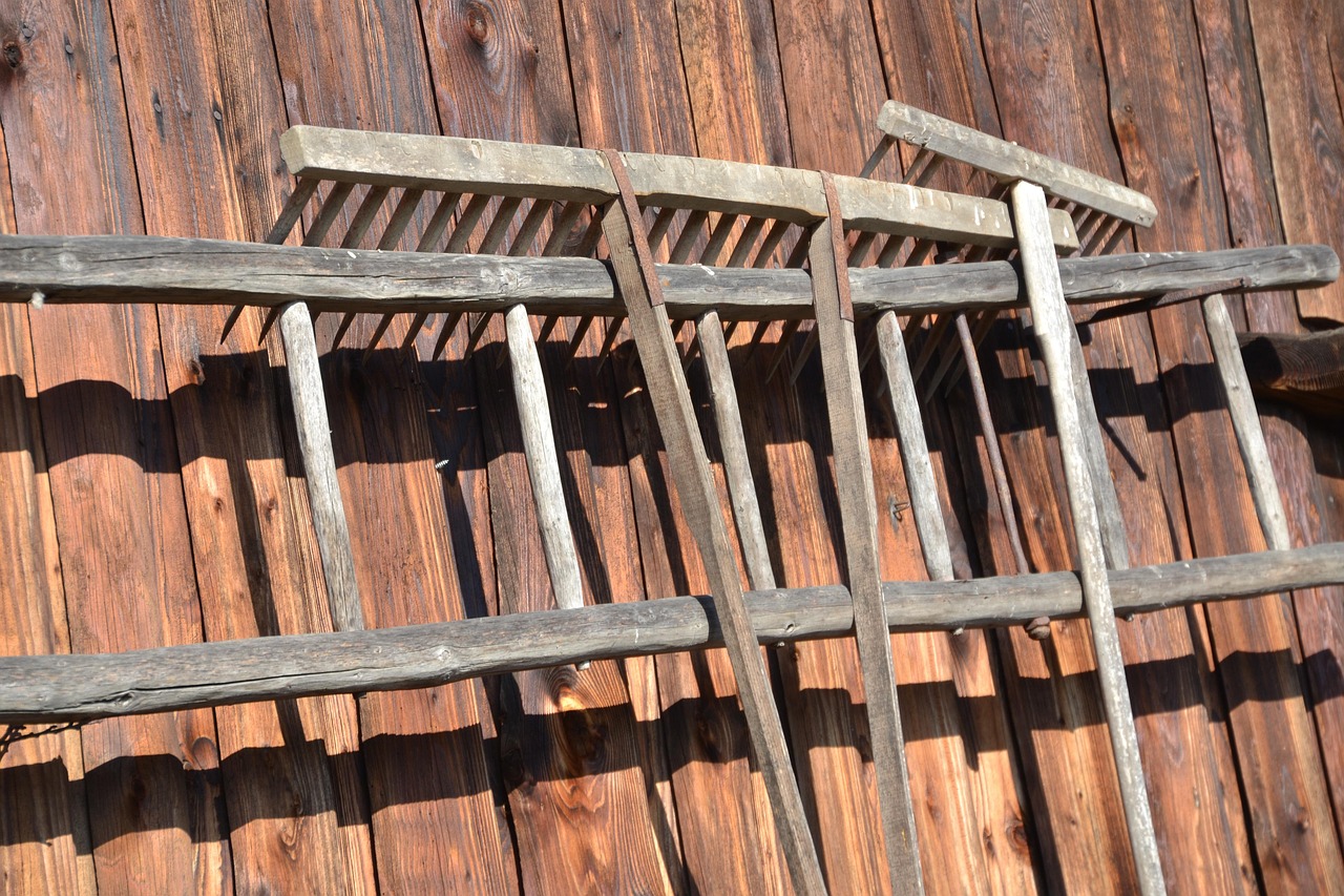 Strumenti da giardino in legno, trascurati e danneggiati, su un tavolo di lavoro.