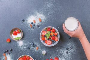 Un bicchiere di latte vegetale circondato da ingredienti naturali e freschi.