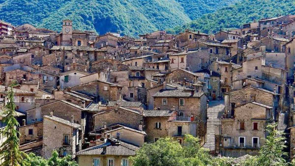 Festa tradizionale nel borgo dell'Appennino, con pochi abitanti festanti e decorazioni colorate.