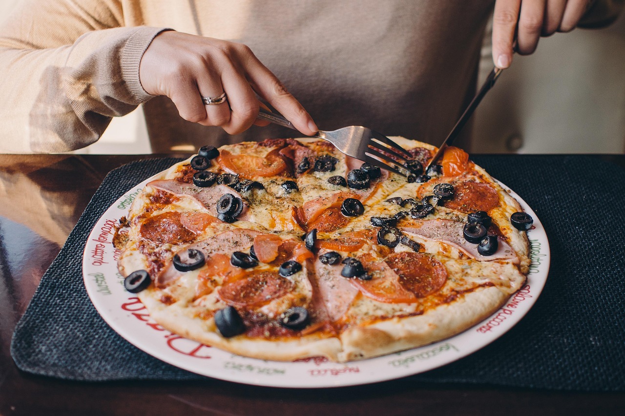 Pizza su un tavolo con un misuratore di glicemia accanto, evidenziando le preoccupazioni per la salute.